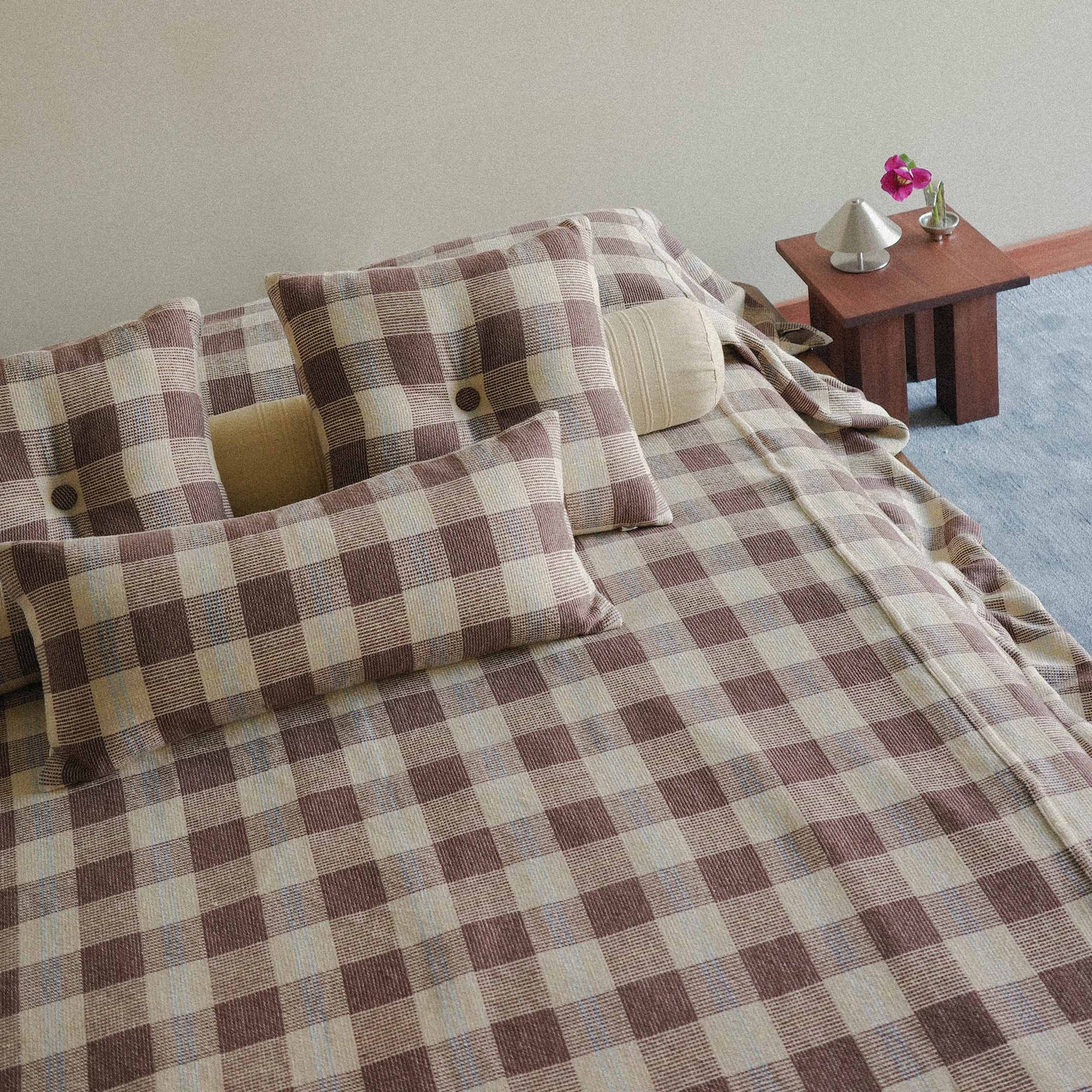 The checkered Mina bed cover in a bright bedroom setting. 