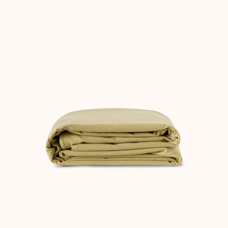 Folded green duvet cover on a white background