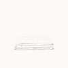 A neatly folded matte sateen white fitted sheet against a white background.